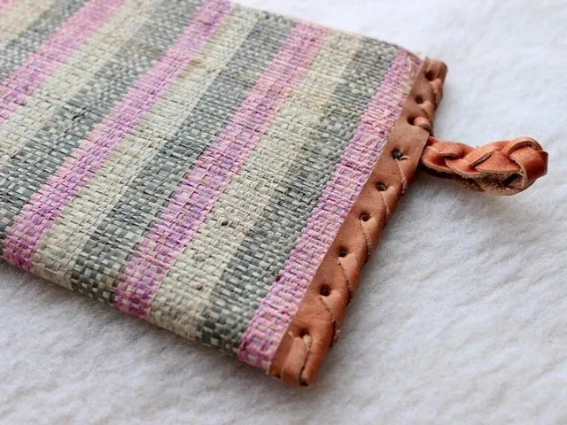 pink, green, and cream striped raffia woven clutch with leather trim